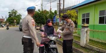 AKP Monang (kanan) pada saat membagikan masker kepada masyarakat setempat. F : mael/detak.media