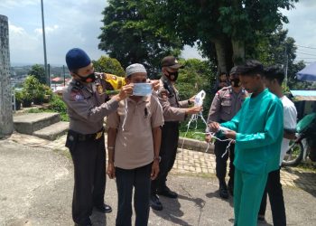 Personil Polsek Batu Ampar pada saat memasangkan masker kepada salah seorang jamaah, f : ist