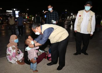 Arif Fadillah saat memasangkan masker kepada seseorang anak di G 1, Tanjungpinang, f : ist