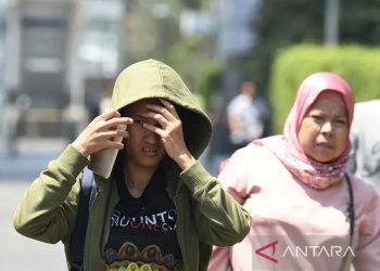 Arsip foto - Warga menghalau sinar matahari dengan pakaiannya saat melakukan aktivitas di kawasan Bundaran Hotel Indonesia, Jakarta, Selasa (22/10/2019). ANTARA FOTO/Muhammad Adimaja/foc.