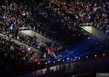 Sejumlah seporter Tim Indonesia mengibarkan bendera saat defile pada upacara pembukaan SEA Games 2021 di Stadion Nasional My Dinh, Hanoi, Vietnam, Kamis (12/5/2022). ANTARA FOTO/Zabur Karuru/YU (ANTARA FOTO/ZABUR_KARURU)