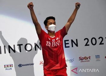 Pebulu tangkis tunggal putra Indonesia Anthony Sinisuka Ginting merayakan di podium setelah mengalahkan Kodai Naraoka dari Jepang pada final tunggal putra di turnamen bulu tangkis Singapura Open 2022 di Singapura pada, Minggu (17/7/2022). ANTARA/Roslan Rahman/AFP/pri.