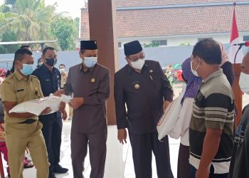 Caption: Walikota Blitar Santoso dengan di dampingi oleh Ketua DPRD Kota dr. Syahrul, saat sedang bagikan Rastrada tahap II di Kelurahan Gedog, foto : Dani ES/detak.media.