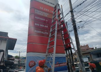 Petugas saat Mengubah Daftar Harga BBM di Menara SPBU Jalan Ir Sutami Tanjungpinang, foto : Mael/detak.media