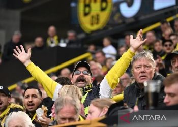 Arsip - Suporter Borussia Dortmund bereaksi saat mendukung tim kesayangannya menghadapi VfL Bochum dalam pertandingan Liga Jerman 2021-22 di Stadion Signal Iduna Park, Dortmund, Jerman, Sabtu (30/4/2022). (ANTARA/AFP/Ina Fassbender)