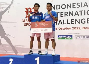 Pasangan ganda putra Indonesia Pramudya Kusumawardana (kanan) dan Rahmat Hidayat menunjukkan medali emas usai menjuarai turnamen bulu tangkis Indonesia International Challenge 2022, di Kota Malang, Jawa Timur, Minggu (16/10/2022). ANTARA/Vicki Febrianto.