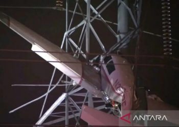 Sebuah pesawat kecil menggantung sekitar 100 kaki (33 meter) di atas tanah setelah menabrak menara listrik di Gaithersburg, Maryland, AS, 27 November 2022 dalam gambar diam dari video. (ABC affilate WJLA via REUTERS/as)