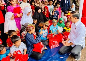 Presiden Jokowi membagikan makanan kepada anak-anak di posko bencana gempa bumi BIN di Desa Cijedil, Kecamatan Cugenang, Kabupaten Cianjur, Provinsi Jawa Barat, pada Kamis (08/12/2022). (Foto: BPMI Setpres/Laily Rachev)