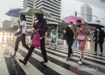 Warga berjalan menggunakan payung saat hujan lebat di kawasan Sarinah Thamrin, Jakarta, Selasa (5/4/2022). ANTARA FOTO/Muhammad Adimaja/hp/aa.