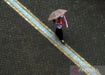 Ilustrasi - Seorang warga berjalan menggunakan payung saat hujan turun di Kota Makassar, Sulawesi Selatan. ANTARA FOTO/Abriawan Abhe.