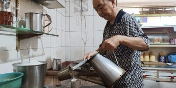 Pemilik Kedai Kopi Damai Baru, Acong (72) saat Menuangkan Kopi Dari Teko ke Cangkir Berbahan Keramik, foto: Mael/detak.media