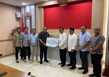 Deputi Direktur BPJS Ketenagakerjaan Wilayah Sumbar,Riau,Kepri Eko Yuyulianda (kiri) saat menyerahkan santunan sebesar Rp.1.2 miliar secara simbolis yang diterima oleh Sekda Natuna, Boy Wijanarko (foto : ist)