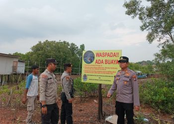 Polisi saat Memasang Palang Peringatan Ada Buaya di Kampung Kolam Jalan Salam Tanjungpinang, foto: Mael/detak.media