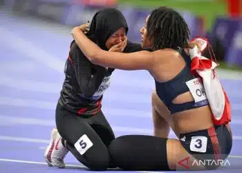 Sprinter Karisma Evi Tiarani (kiri) menangis terharu dalam pelukan sprinter Britania Raya Ndidikama Okoh (kanan) setelah berhasil finis di urutan kedua pada pertandingan final nomor 100 meter T63 putri Paralimpiade Paris 2024 di Stadion Stade de France, Paris, Prancis, Sabtu (07/09/2024). Karisma Evi berhasil finis di urutan kedua dan berhak atas medali perak dengan catatan waktu 14,26 detik. ANTARA FOTO/Agung Wahyudi/app/agr