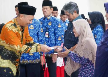 Ketua DPRD Kota Blitar, dr Syahrul Alim memberikan secara simbolis kartu rastrada non-tunai kepada warga penerima manfaat.